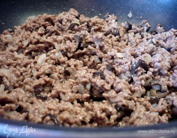 Для мясной начинки порежем меленько лук и, поджарив в оливковом масле фарш, добавим его в сковороду, обжарим лук с фаршем пару минут и всыпем муку, а затем зальем бульон и все хорошо перемешаем. Оставим тушить на маленьком огне 10 минут. А пока порежем мелко оливки. Фарш снимем с огня и перемешаем с оливками, посолим и поперчим по вкусу.