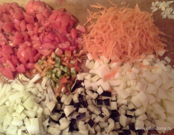 Режем овощи:лук, цукини, баклажан, перец кубиком. Морковь трем на терке.
Помидоры обдаем кипятком и снимаем кожицу, режем кубиком. 
Чеснок мелко нарезаем.