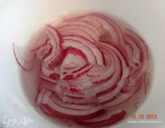 Луковицу очистить, нарезать тонкими полукольцами и залить кипятком на пару минут, чтобы ушла лишняя горечь.