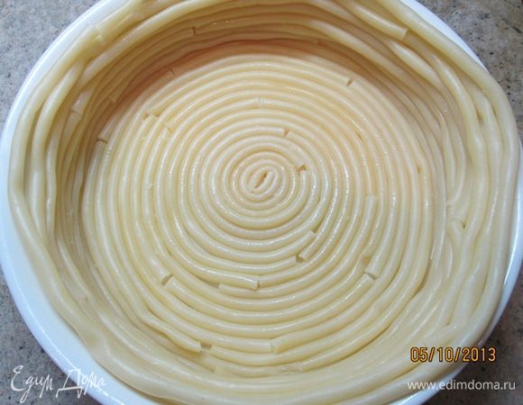 Круглую форму смазать сливочным маслом. Начиная с центра, выложить по кругу дно и бока формы макаронами.