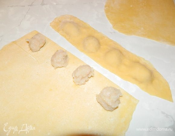 Тесто достать из холодильника, разрезать на 4 части, раскатать в тонкие пласты. На один пласт на небольшом расстоянии друг от друга выложить кусочки фарша, сверху накрыть другим пластом теста, пальцами прижать края, разрезать на кусочки.