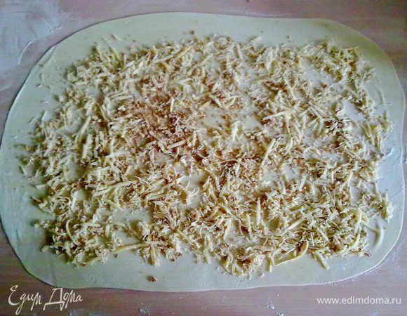 Тесто раскатать в тонкий пласт и распределить сыр с сухарями. 