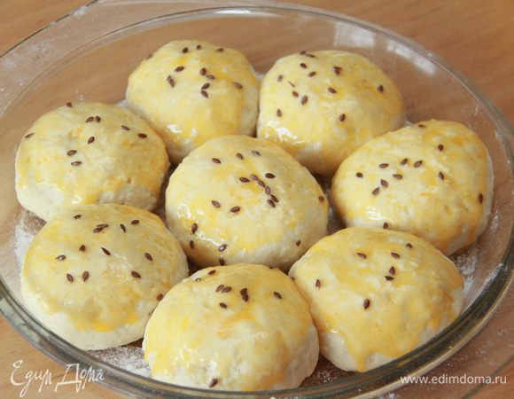 Булочки накрыть полотенцем и оставить на подъём на 30 минут (можно больше). Перед выпечкой смазать поверхность булочек желтком, посыпать семенами льна.