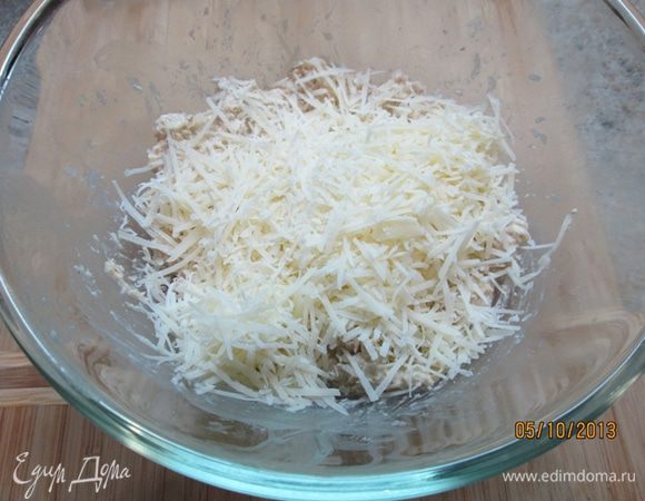 Нарезать масло кубиками, добавить в сухие ингредиенты. Влить молоко, вымесить тесто.
Добавить натертый на терке сыр "Джюгас", перемешать.