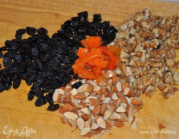 Орехи прокалить на сковороде, остудить и крупно порубить, сухофрукты промыть и мелко нарезать, кроме изюма,
