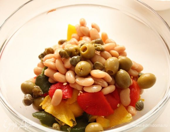 С фасоли слить жидкость,добавить к перцам. Также добавить каперсы и оливки.