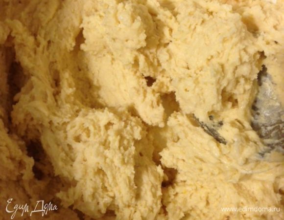 Добавьте мучную смесь к яично-масляной, перемешайте ложкой до состояния теста, добавьте шоколадные капли или порубленный ножом шоколад и миндальные лепестки, еще раз перемешайте. Выложите тесто на присыпанную мукой поверхность и вымесите его в течение одной-двух минут, не больше. Тесто должно быть влажным, но не липким, можно добавить столовую ложку муки...