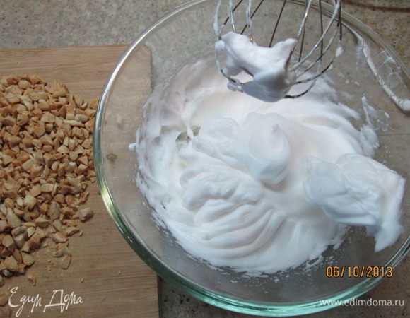 В миске взбить белки в крепкую пену, добавить миндаль, немного корицы, 180 г сахарной пудры, перемешать.