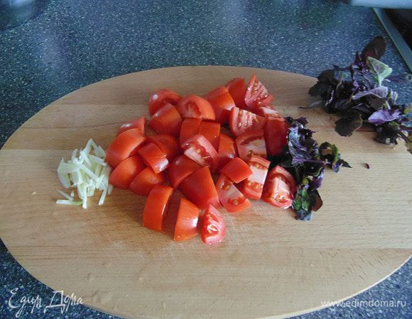 В это время, порезать помидоры крупными дольками. Добавить немного чеснока и базилика.