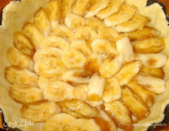 Бананы нарежьте дольками и выложите в форму на тесто.