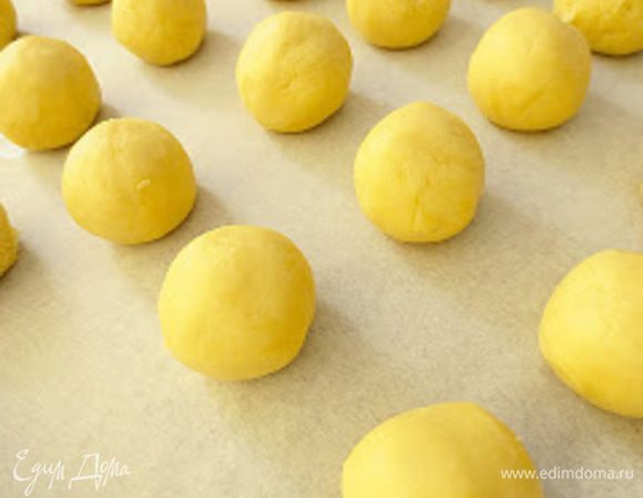 Разделить тесто на маленькие кусочки и сформировать из них колобки. Противень застелить бумагой для выпечки и выложить колобки.