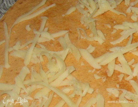 Накройте второй половиной лепешки. Уложите кесадильи на противень, застеленный пергаментом, смажьте растительным маслом, слегка присыпьте тертым сыром и запекайте в разогретой до 210 С духовке 7-8 минут до золотистого цвета.