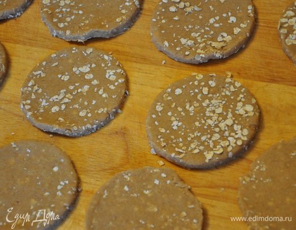 Рабочую поверхность посыпать хлопьями и раскатать на них тесто в пласт толщиной 3 мм., вырезать круглой формочкой печенье, обрезки теста снова раскатывайте и снова вырезайте, так пока не останется теста. 