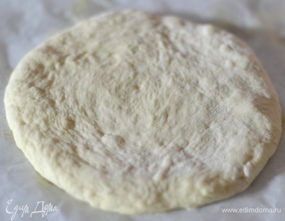 Поднявшееся тесто разделить на 4 части,выложить на пергамент, слегка присыпанный мукой и сформировать руками лепешки. Накрыть полотенцем и оставить на 10 минут. 