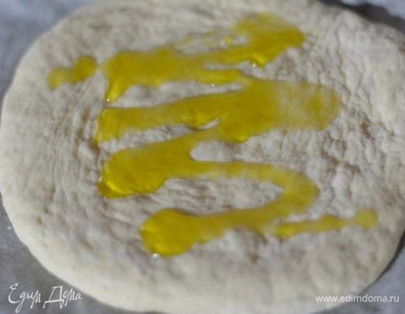 Полить пиццу оливковым маслом, кисточкой смазать. 