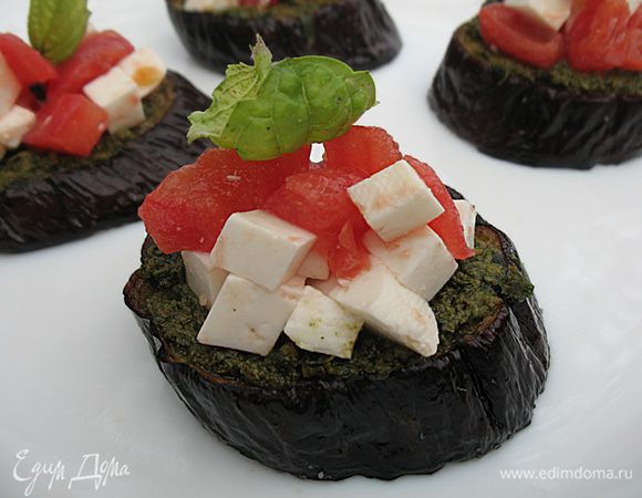 На кружочек баклажана выложить соус песто и смесь из помидора и брынзы.  