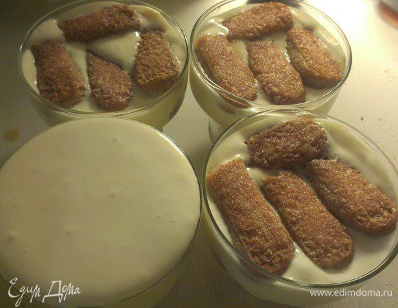 Выложить половину смеси с маскарпоне на печенье. Окунуть оставшееся печенье в смесь кофе с ромом и уложить плотным слоем. Сверху выложить второй слой маскарпоне. 