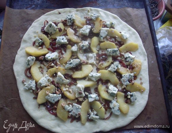 Для того, чтобы пицца была румяной и хрустящей снаружи, и нежной внутри, температура ее приготовления должна быть около 300 - 280 градусов. В домашних условиях мне удается достигнуть максимум 265 градусов (у меня большая газовая духовка). Кроме того, я пользуюсь одним секретом, который вычитала в интернете. Беру два противня. Один из них переворачиваю обратной стороной (если противень со скосом, чтобы выпечке удобно было с него соскальзывать, можно его не переворачивать) застилаю тефлоновым листом (можно фольгой, пергаментом), а второй разогреваю внутри духовки. На оставшийся снаружи противень с тефлоновым листом выкладываю тесто, на тесто лук, сверху яблоки и сыр в произвольном порядке, присыпаю все это грецкими орешками. Когда температура поднимается до максимума, достаю горячий противень и на него скидываю (соскальзываю) тефлоновый лист с пиццей. Сразу же в духовку на 9-10 минут. 