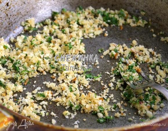 На сковороде разогреваем оливковое масло. Кладём чеснок, обжариваем. Добавляем петрушку и хлебные крошки, жарим до румяного цвета хлеба.