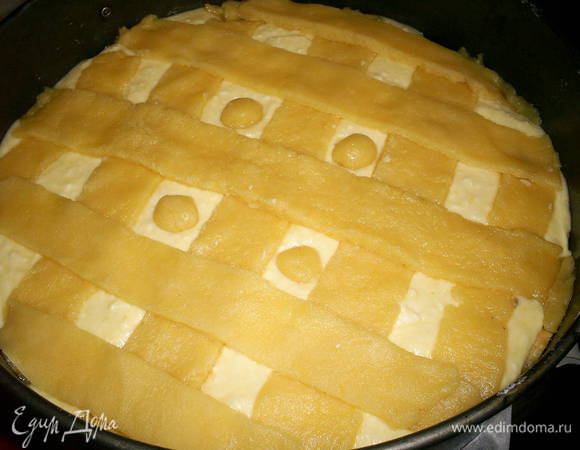 Оставшееся тесто раскатываем, нарезаем широкими полосками и делаем решетку сверху начинки. 