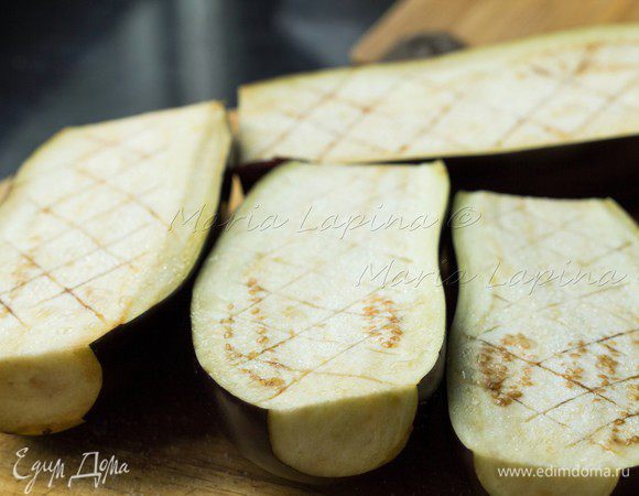 Баклажаны разрезать вдоль на две половины. Сделать глубокие надрезы крест на крест, посолить мякоть и отставить в сторону на 10-15 минут. 