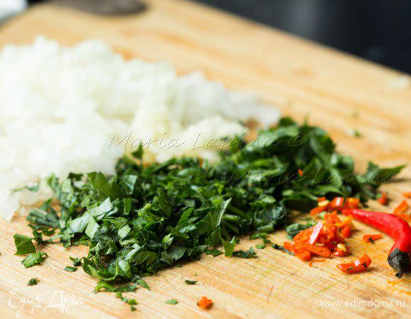 Тем временем подготовим начинку и соус. Нашинкуем мелко лук, чеснок, зелень и перец чили. Будьте осторожны с перцем чили, иногда самый маленький перчик может дать очень сильную остроту. Например, перчик как намоем фото сделает блюдо очень острым, если его использовать с семенами и прожилками.