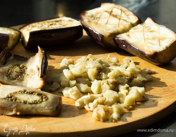 Баклажаны должны выйти из духовки размягченными, но не полностью приготовленными. Разрезаем каждую лодочку поперек и достаем всю мякоть баклажана. Делаем это аккуратно, чтобы не повредить кожицу баклажана и оставляем немного мякоти на коже, чтобы она была потолще. Мякоть, если нужно, нарезаем мелкими кубиками. 