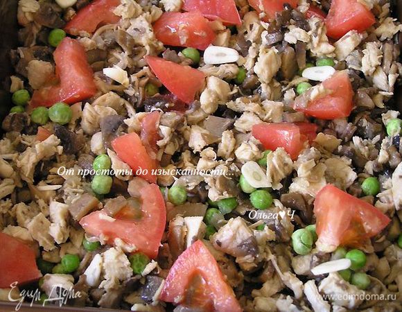 Сверху разложить зеленый горошек, мелко нарезанный чеснок и кусочки помидора.