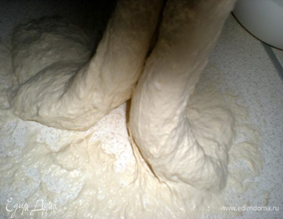 Начинаем замешивать тесто. Всыпать муку в миску, втереть пальцами дрожжи. Выложить к муке закваску. Добавить воду,соль и масло. Начинаем тщательно вымешивать тесто. Одной рукой держим миску,а другой перемешиваем. Когда тесто начнет отлипать от стенок, выкладываем его на смазанный маслом стол и вымешиваем. Я смазываю руки маслом, так легче работать с тестом.