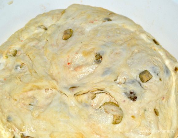 Тщательно перемешиваем. Распределяем оливки по всему тесту. И оставляем еще на 40 минут в теплом месте и не забываем закрыть полотенцем.