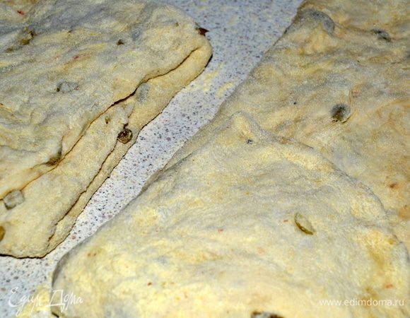 Затем щедро припорошить стол кукурузной мукой и выложить тесто. Сверху так же присыпать мукой. Ладошками расправить тесто в прямоугольный пласт. Разделить на 3-4 одинаковые полосы. Каждую сложить втрое. Одну треть завернуть к середине и запечатать,потом сложить к центру другую сторону и опять прижать ладонью.