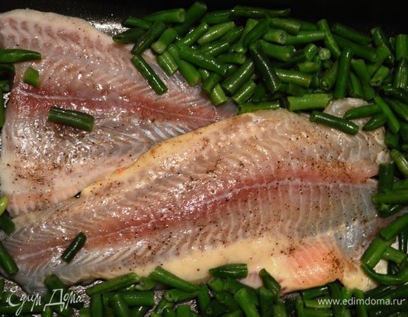 В смазанную маслом форму для выпечки положить натертое солью и перцем рыбное филе (можно чуть-чуть сбрызнуть лимонным соком). Свободное пространство формы заполнить мороженой зеленой фасолью, немного посолить (если не хотите много жидкости - можно предварительно слегка разморозить фасоль, как я и сделала).