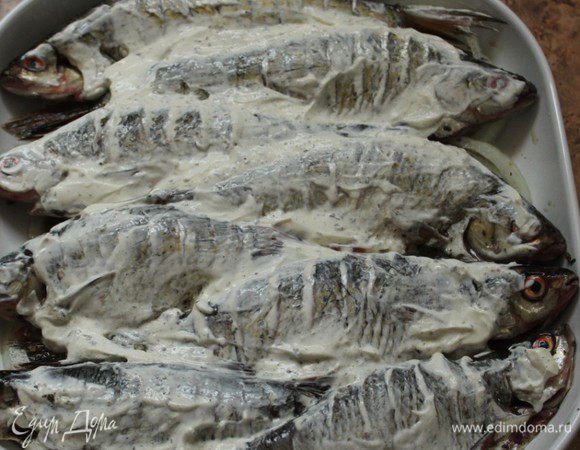 Равномерно намазать рыбу сметаной и отправить в разогретую до 180 градусов духовку.