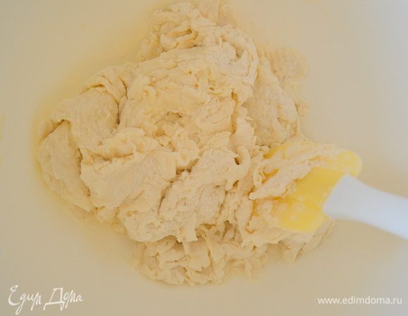 В муку влить дрожжи, 150 мл теплой воды и оливковое масло и замесить тесто.
