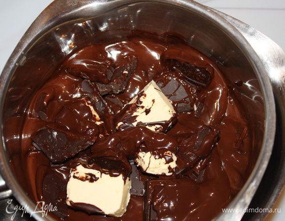 Готовим торт:
Растворить куски измельченного шоколада на паровой бане. Сливочное масло порезать кубиками и медленно вводить их в шоколадную смесь пока масса не станет однородной. Затем снять с огня и дать смеси немного остыть.