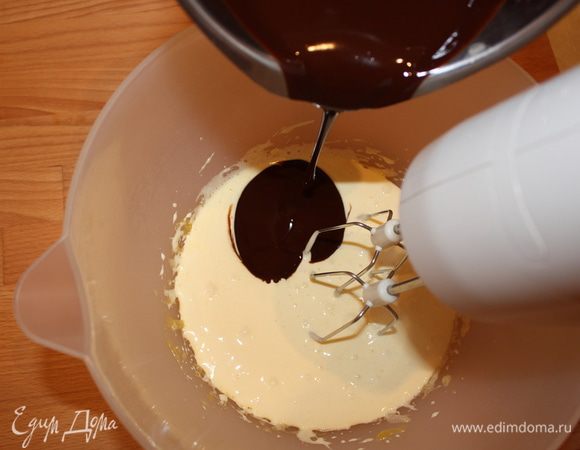 Отделить желтки от белков. Взбить желтки с половиной сахара, пока смесь не станет воздушной. Добавить шоколадную массу, молоко, муку и все хорошо перемешать.
