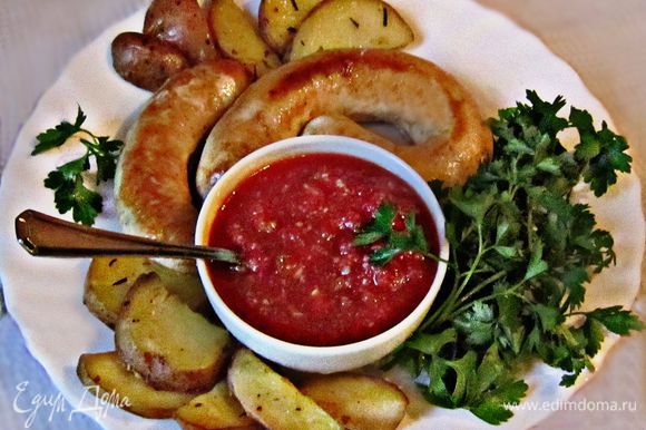 Готовые румяные колбаски подавайте с томатным соусом, зеленью и запечённым картофелем. Приятного аппетита!