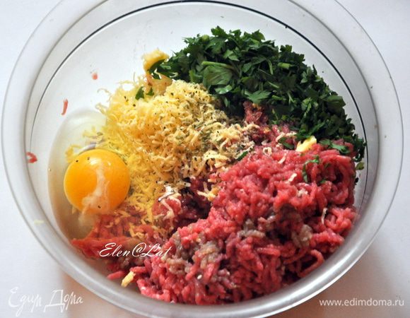 В говяжий фарш добавить яйцо, тертый сыр, орегано, базилик, соль, перец и нарезанную петрушку.