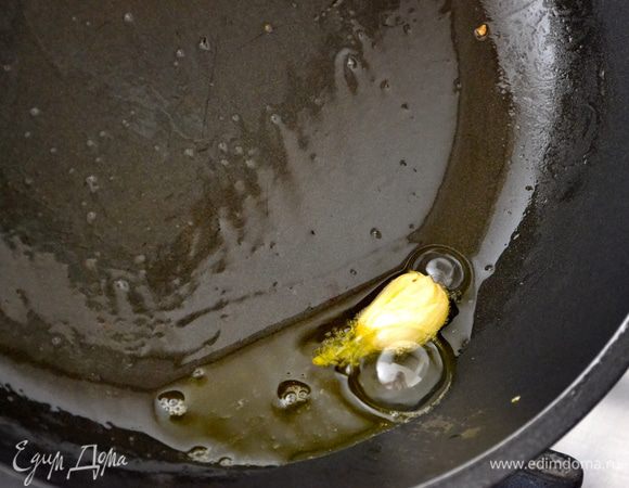 Поставить на огонь большую кастрюлю с водой для пасты. Копченую грудинку (бекон) нарезать небольшими кубиками. 
Кабачки вымыть и также нарезать небольшими кубиками. 
В глубокой сковороде разогреть оливковое масло и положить обжариваться неочищенный зубчик чеснока ("в рубашке"). 