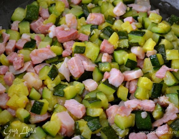 Как только чеснок слегка зарумянится, вытащить его из масла и выложить обжариваться нарезанный кабачок. Добавляя понемногу горячий бульон, дать кубикам цукини слегка поджариться. Уменьшить огонь до маленького и продолжать тушить кабачки около 15 минут, не забывая время от времени помешивать. Затем добавить к овощам кубики грудинки. Обжаривать минуты 3-4 все вместе. Проконтролировать на соль. Слегка поперчить (по вкусу). Снять с огня.
