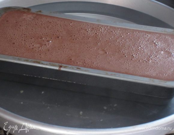 Затем вылить массу на карамель и поставить форму в глубокий противень, наполненный горячей водой (вода должна доходить до 2/3 высоты формы).