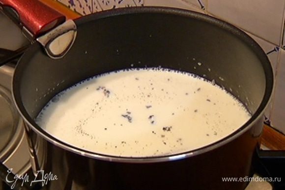 Молоко и сливки влить в кастрюлю, добавить зерна кардамона, стручок и зерна ванили, поместить кастрюлю на огонь и довести до кипения.