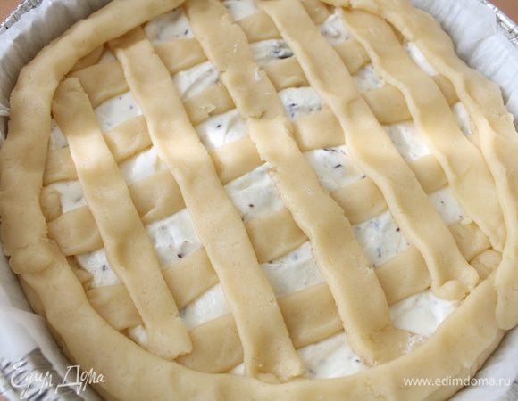 Аккуратно распределить начинку.
Из оставшегося теста сформовать полосочки и украсить верх кростаты в виде решеточки.