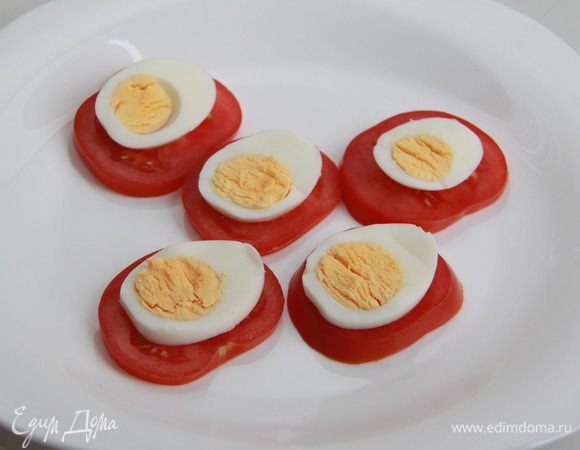 Яйца сварить вкрутую, остудить, почистить. Помидоры и яйца порезать тонкими пластинками. Уложить на ломтики помидора ломтики яиц.