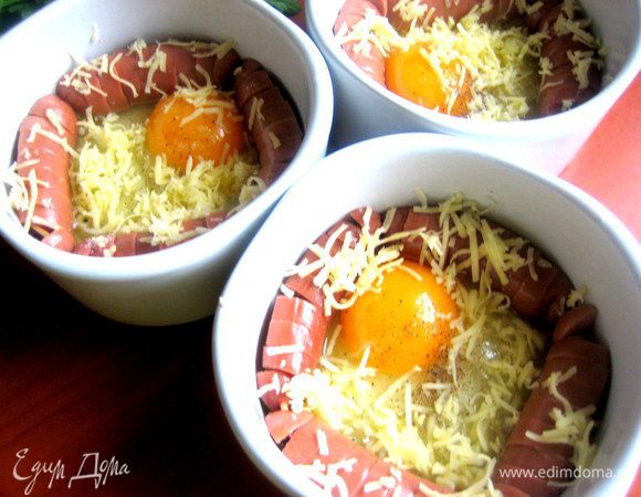 Присыпаем сверху на яйцо и сосиски сыром.