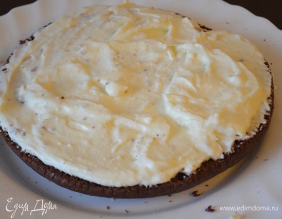 На блюдо кладем шоколадный корж, затем слой ванильного крема - крема много, так что хватит всем коржам. 