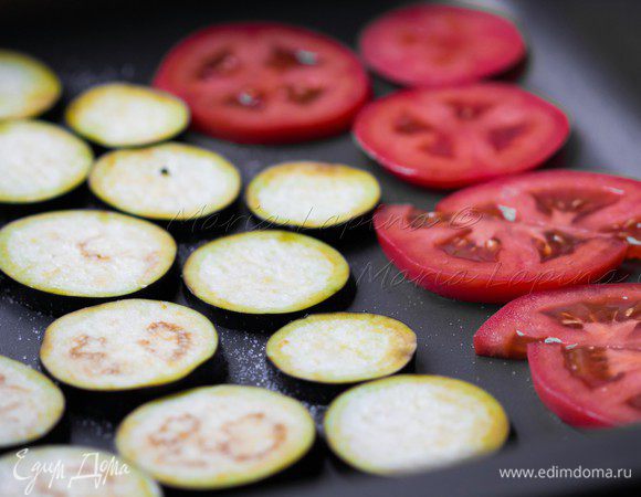 Баклажан помыть и нарезать на кругляшки, посолить и оставить на 5-10 минут. Затем снять с них влагу салфеткой или кухонным полотенцем. Помидор тоже порезать кругляшками, а затем каждый разрезать пополам. В форму выложить приготовленные овощи, посолить, поперчить, сбрызнуть маслом и поставить в духовку на 10-15 минут при температуре 220С на функцию гриль. За это время баклажаны успеют приготовится, а томаты расползутся и станут мягкими.