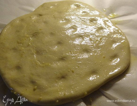 Распластать лепешку руками по противню, застеленному пекарской бумагой.
Смазать щедро верх фокаччи оливковым маслом, сделать пальцами углубления в тесте.
Можно на этом этапе присыпать верх фокаччи крупной морской солью (я так не делаю, предпочитаю добавлять соль в тесто).