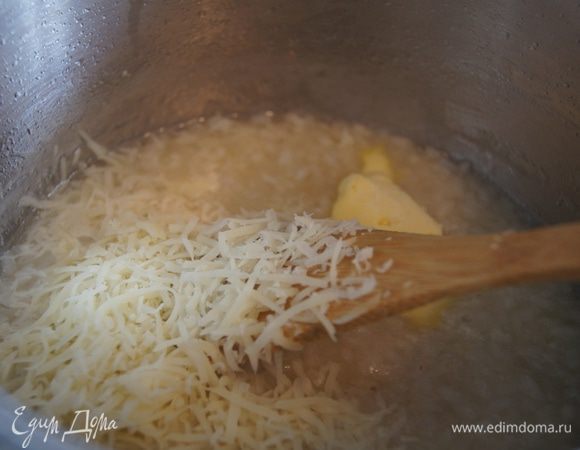 Затем влить половник горячего бульона, огонь сделать средний и помешивая, готовить пока рис не впитает жидкость. Подливая бульон и помешивая рис, довести до готовности ризотто (аль денте), добавить тертый пармезан, сливочное масло и соль по вкусу.