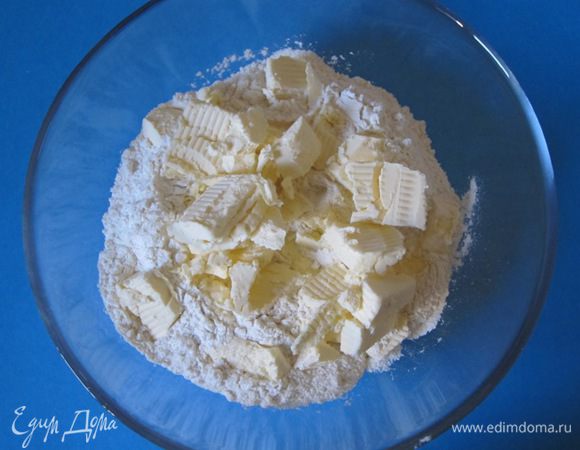 Муку просеять в миску. Сливочное масло нарезать кубиками.